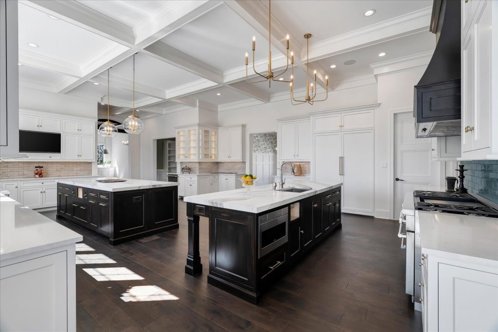Stockell Custom Homes photo of luxury custom home kitchen with two islands, high-end appliances and cabinetry, and coffered ceilings